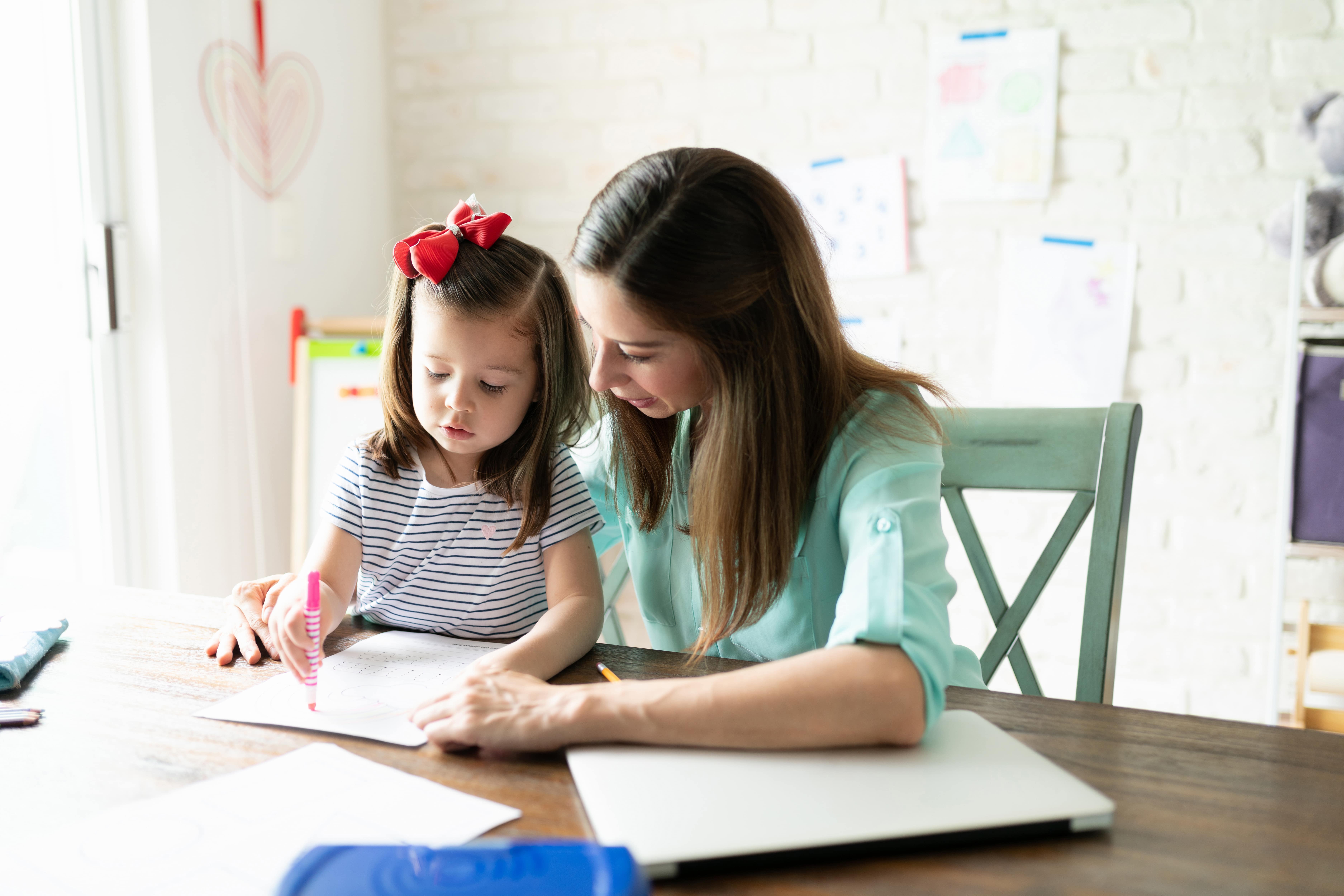 Mom homeschooling her child using math programs.
