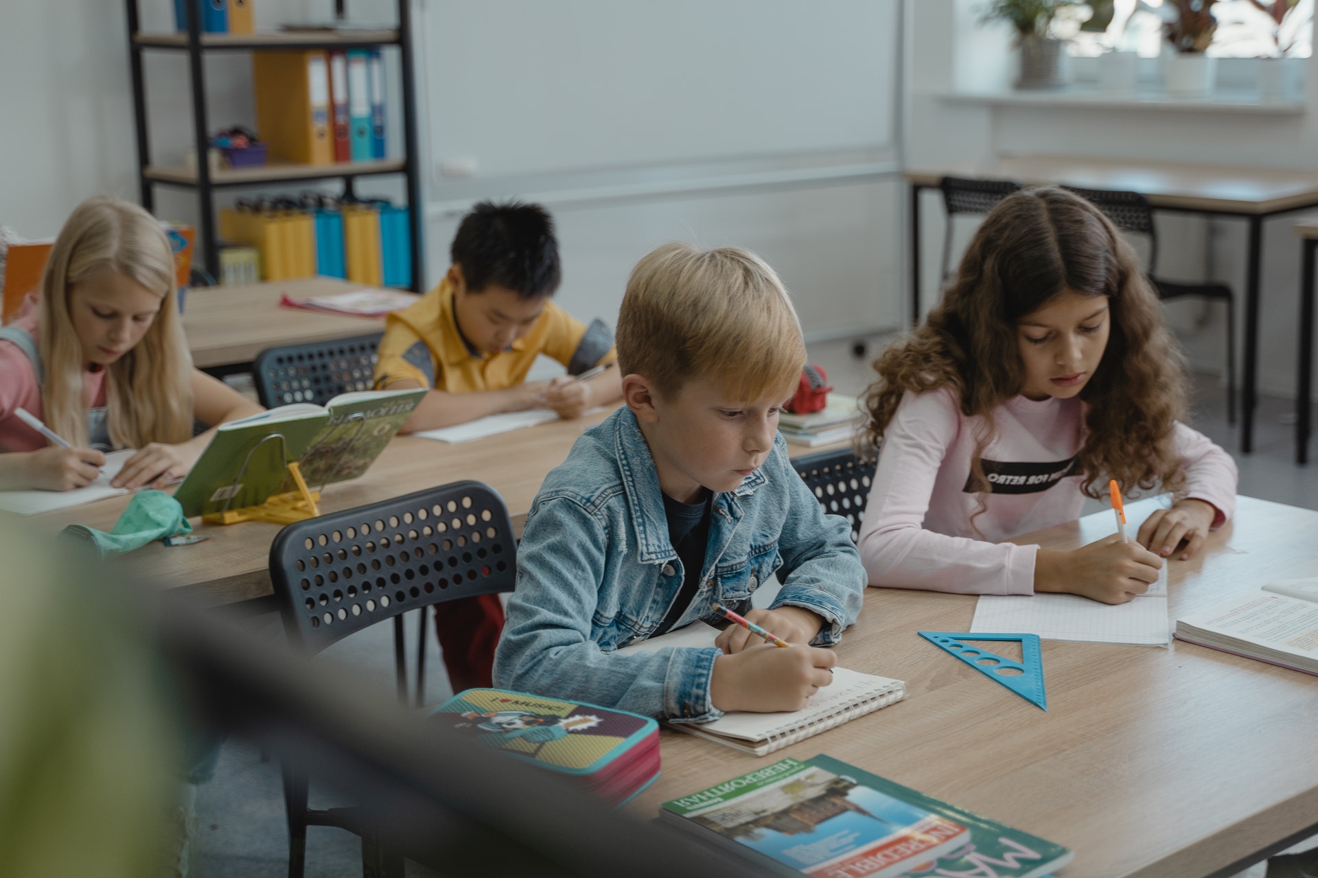 Students sit at desks and work on math assignments in the classroom.