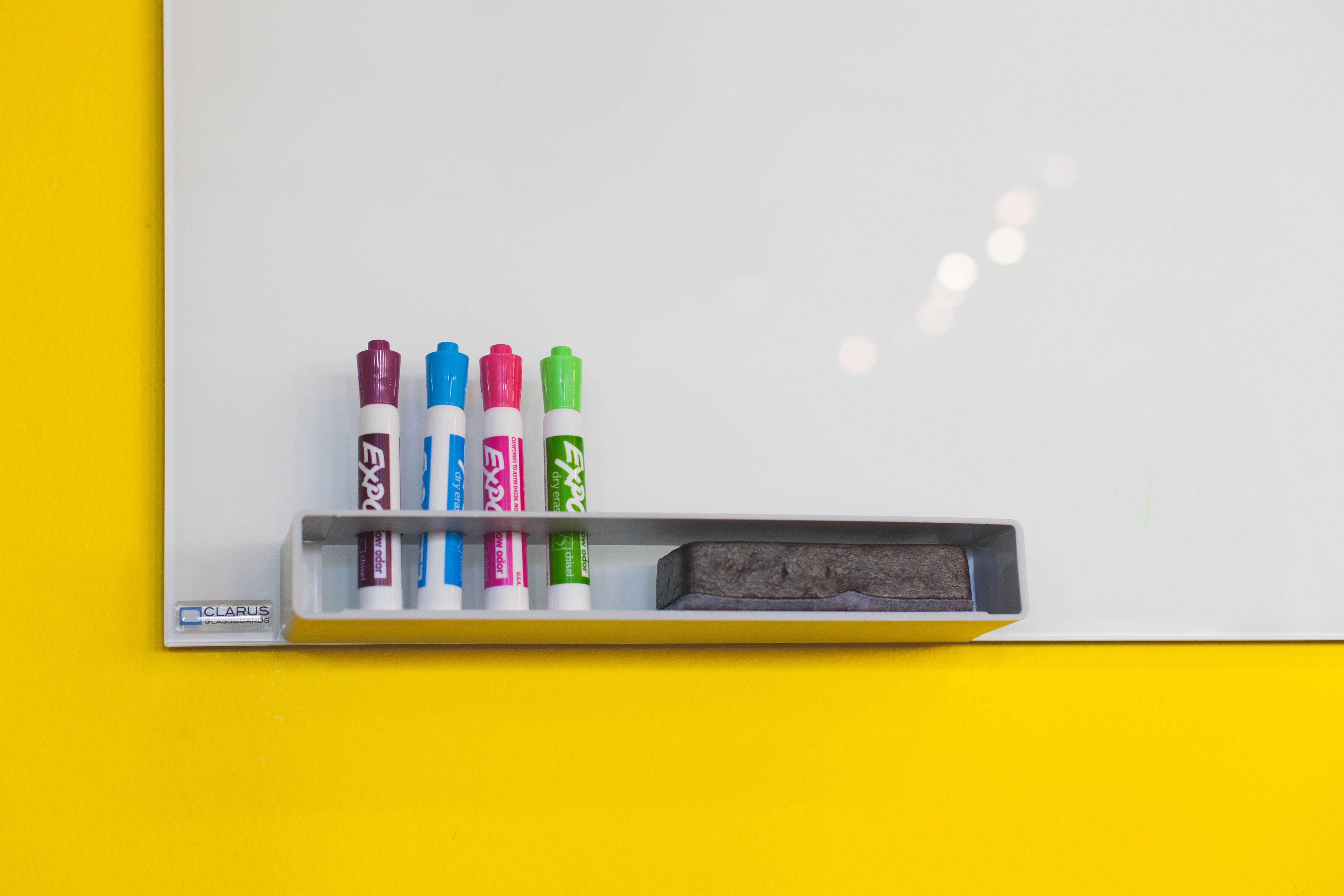 A well-organized white board with dry erase markers and an eraser.